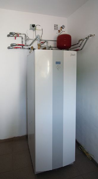 Pompa ciepła Danfos DHP-H 8 o mocy 8 kW zainstalowana w domu o powierzchni 160 m². Zdjęcie wykonane w czasie montażu urządzenia – przed osłonięciem rur izolacją termiczną